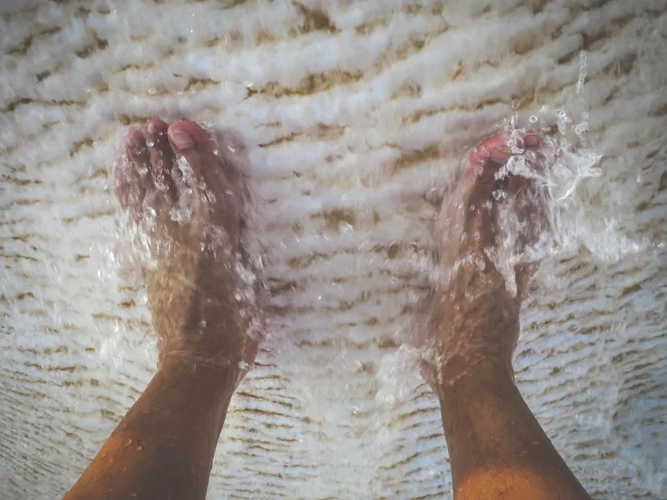 Feet soaking in splashing water, the first step before using a disposable pedicure kit
