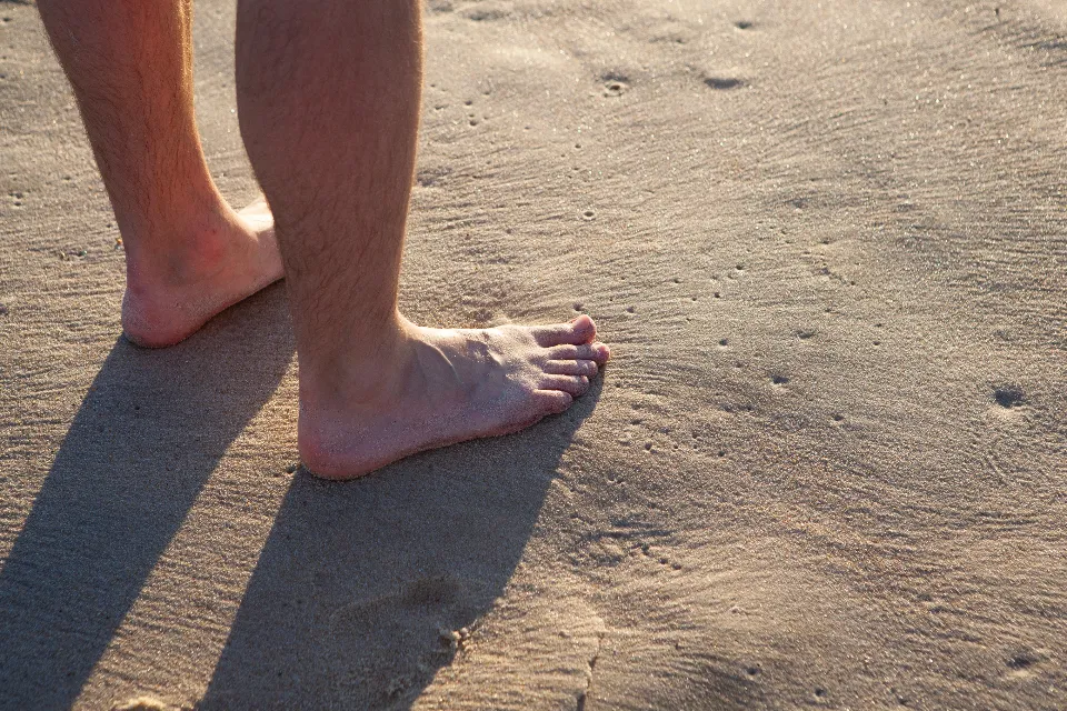 Bare feet and heels on sand, a reminder of how to fix cracked heels with daily care